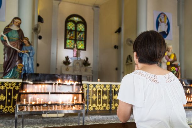 believer kneel and praying in a catholic church maly